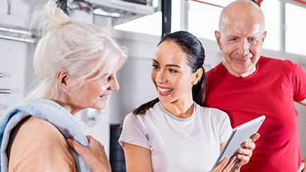 Two older people in discussion with a physical rehab instructor