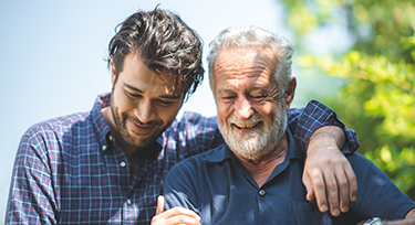 An older man being hugged by a younger man