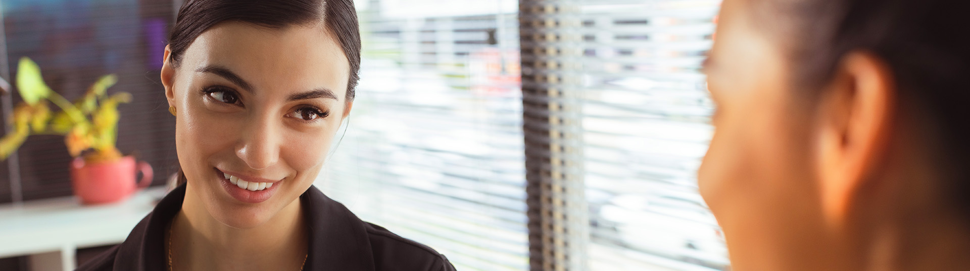 Femail clinician smiling at client during an appointment.