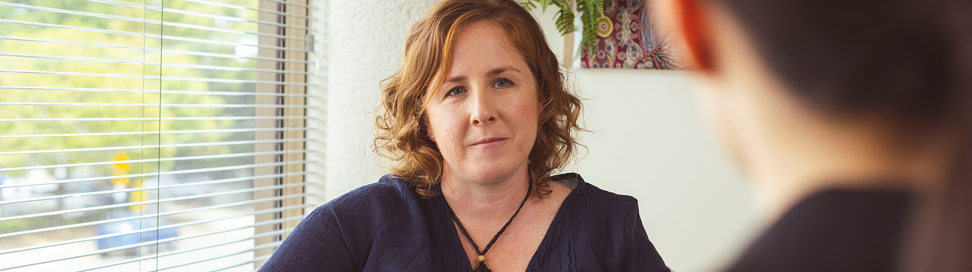 Woman sitting in a social worker appointment.