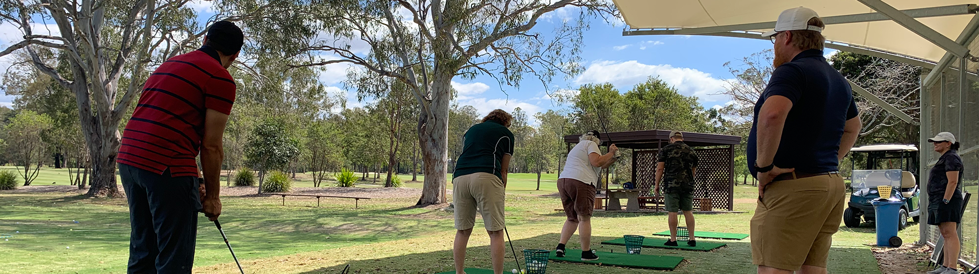 Group playing golf at a driving range.