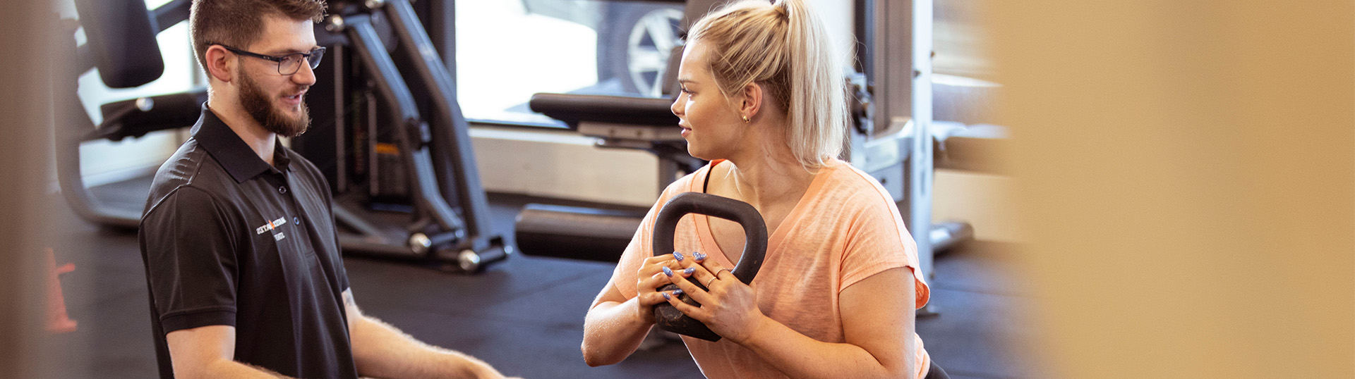 An exercise physiologist works with a woman on a workout routine.